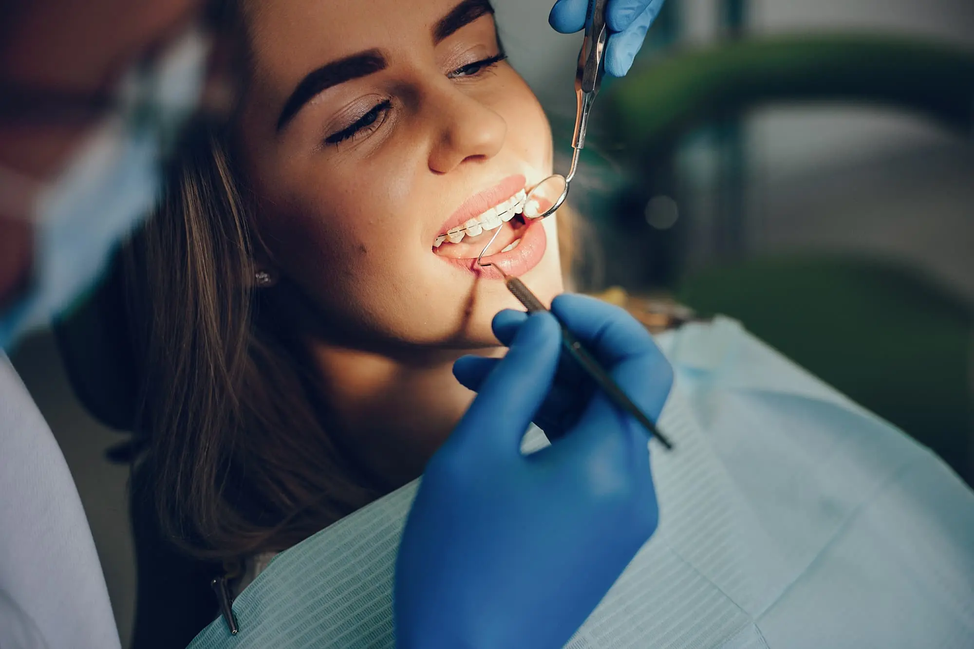 A woman at the dentist is having their teeth examined by a professional and getting affordable braces cost at Natalie Yang Orthodontics in Vacaville, CA.