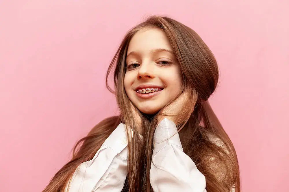 Smiling girl with long brown hair and braces for overbite, promoting Natalie Yang Orthodontics in Vacaville, CA. Smiling girl with long brown hair and braces for overbite, promoting Natalie Yang Orthodontics in Vacaville, CA.