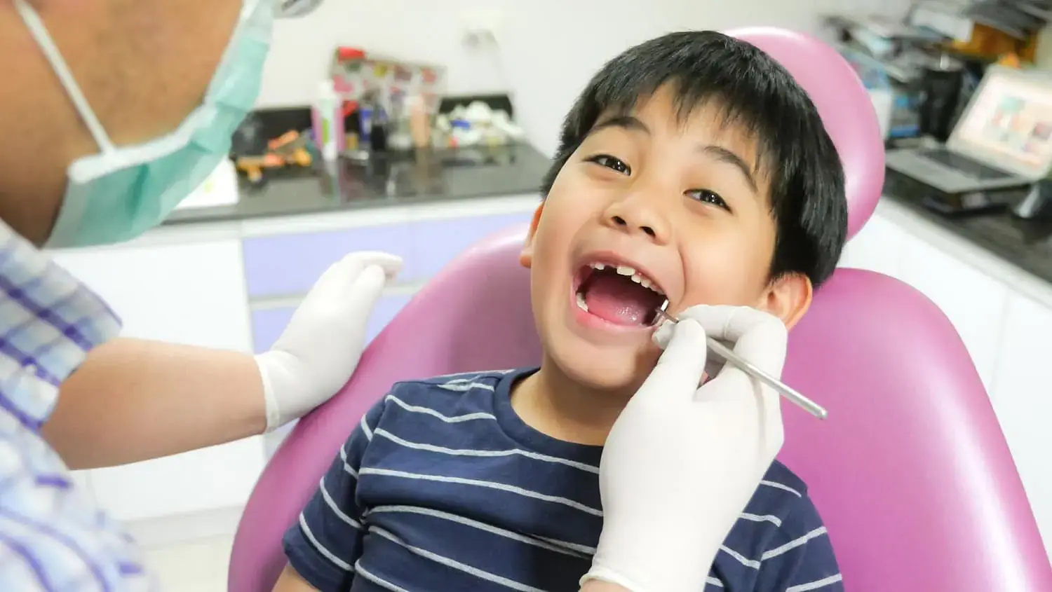 At Natalie Yang Orthodontics Orthodontics in Vacaville, CA, a dentist checks a young boy’s teeth for tongue thrust in the dental chair. At Natalie Yang Orthodontics Orthodontics in Vacaville, CA, a dentist checks a young boy’s teeth for tongue thrust in the dental chair.