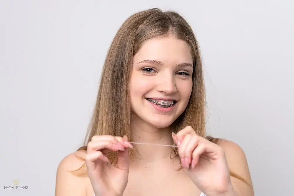 teenager russian girl with metal braces and floss isolated white background - How to Floss with Braces in Vacaville, CA teenager russian girl with metal braces and floss isolated white background - How to Floss with Braces in Vacaville, CA