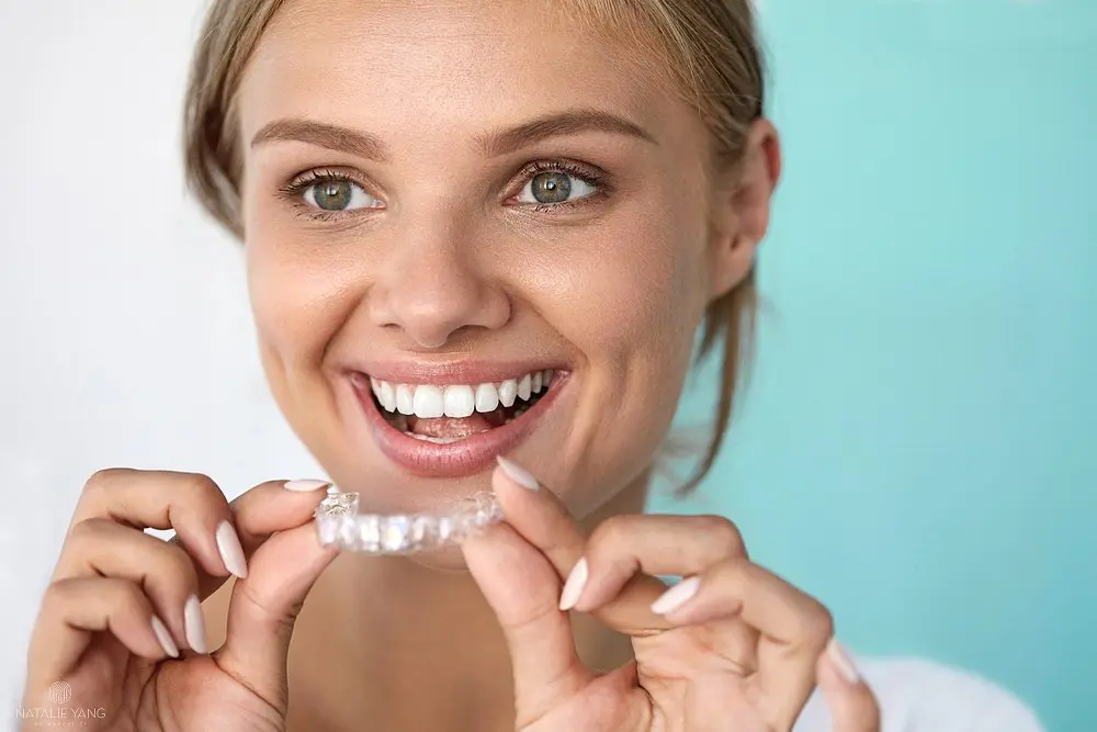 smiling woman with beautiful smile using invisalign clear aligners - How Does Invisalign Work in Vacaville, CA 